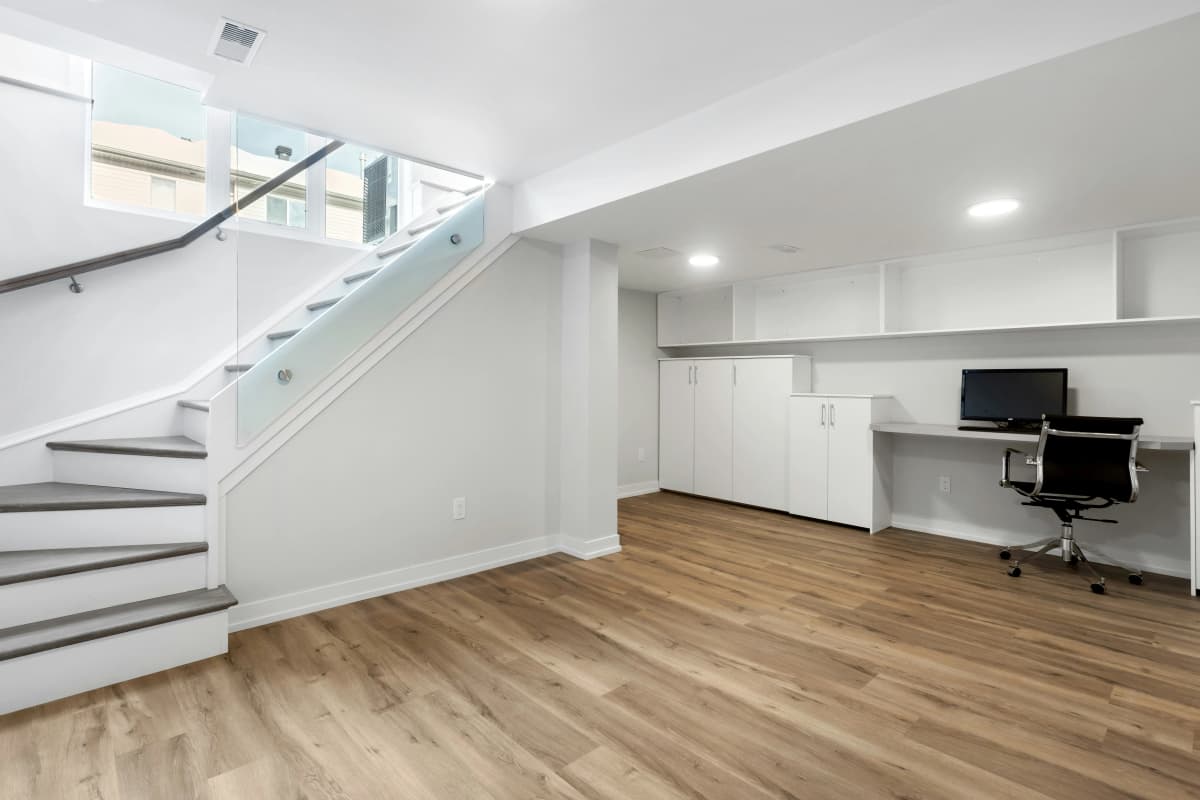 Home gym with rubber flooring and exercise equipment in a finished basement.