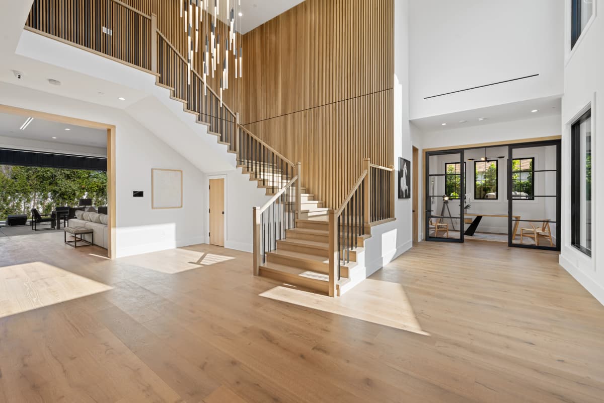 A close-up of high-quality finishing details where new hardwood meets tile.