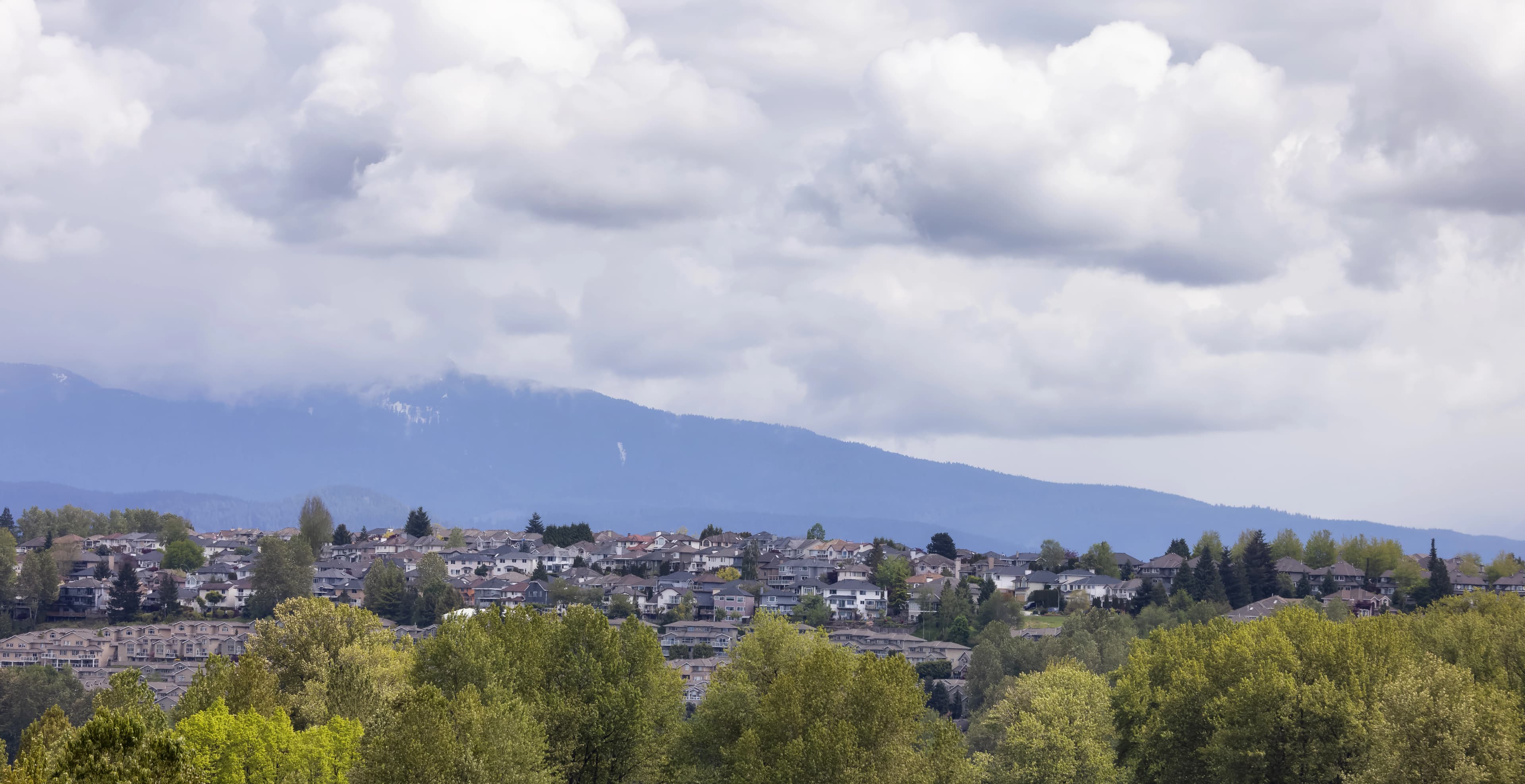 A beautiful farmhouse-style home in Pitt Meadows with the Golden Ears mountains in the background.